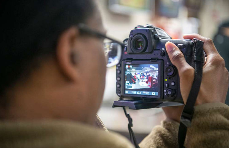 Person using video marketing tools to capture professional footage with a DSLR camera.